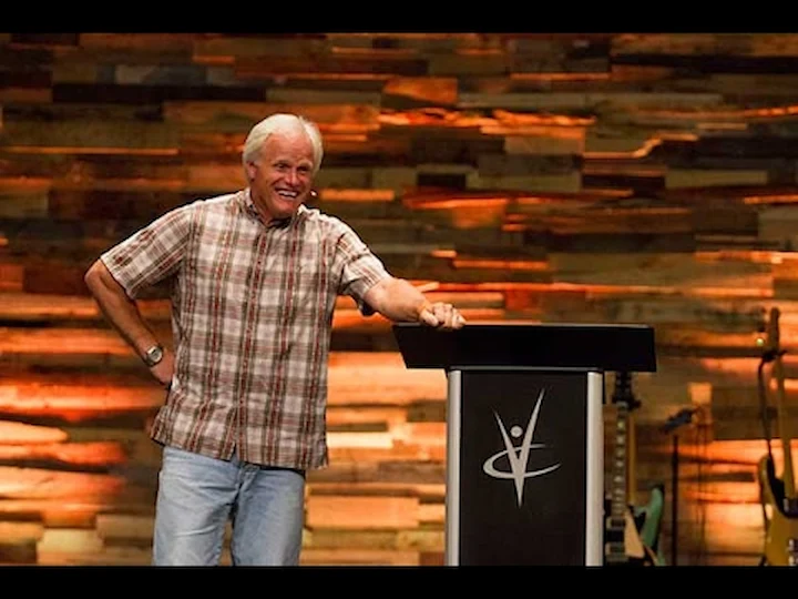 Dan Mohler passionately preaching at a church event with hands raised
